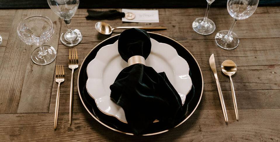 Black and gold place setting for a wedding reception table at 10 South.