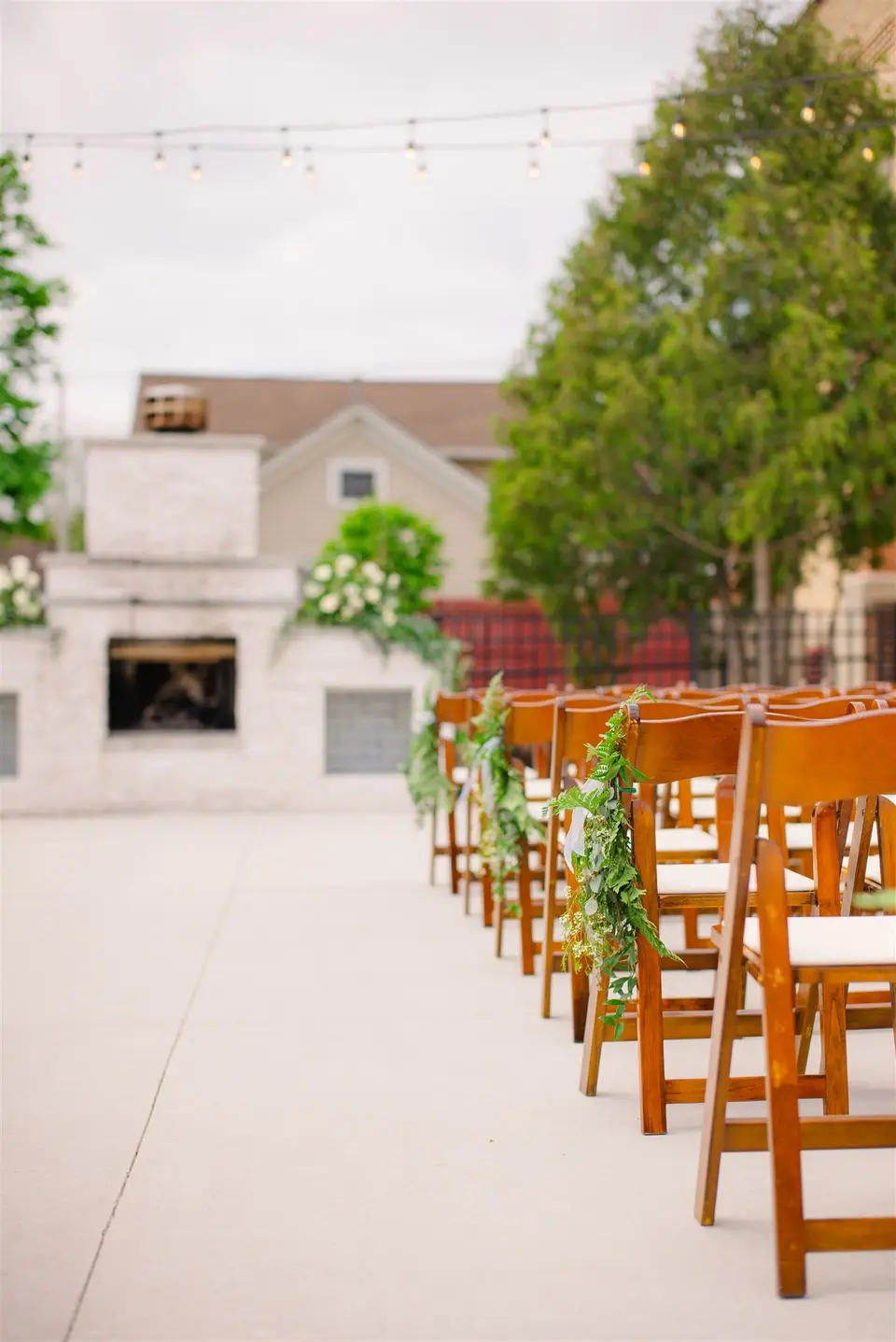 Outdoor wedding ceremony setup with wooden chairs and floral garland at 10 South, a historic Janesville Wisconsin wedding venue