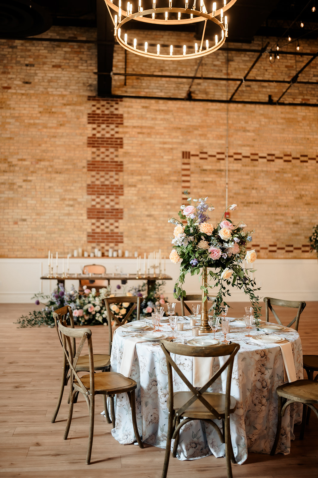 Tall floral centerpiece on a round guest table at 10 South wedding reception in Janesville