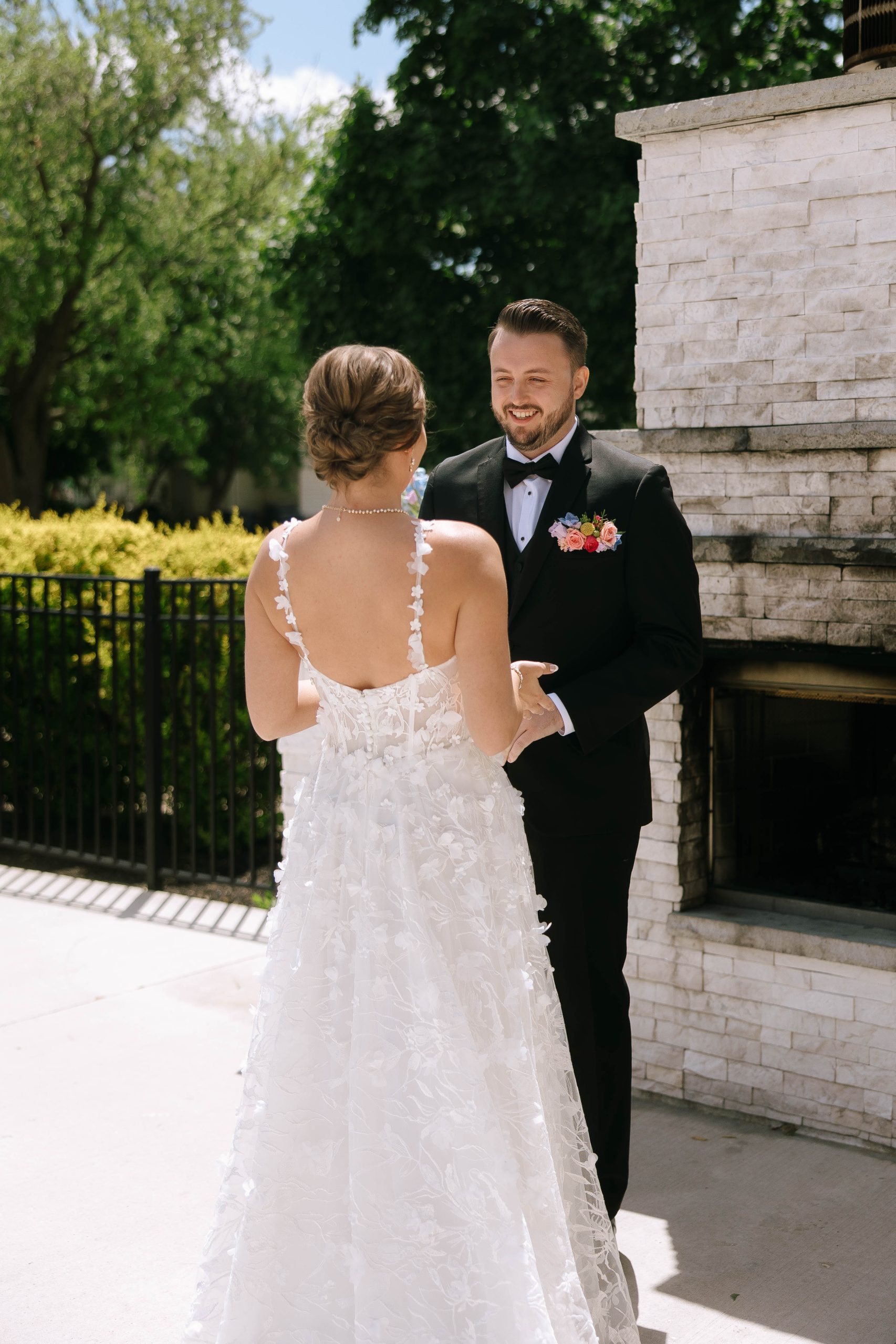 Groom reacts emotionally during a first look with the bride near the white stone fireplace at 10 South in Janesville, Wisconsin.