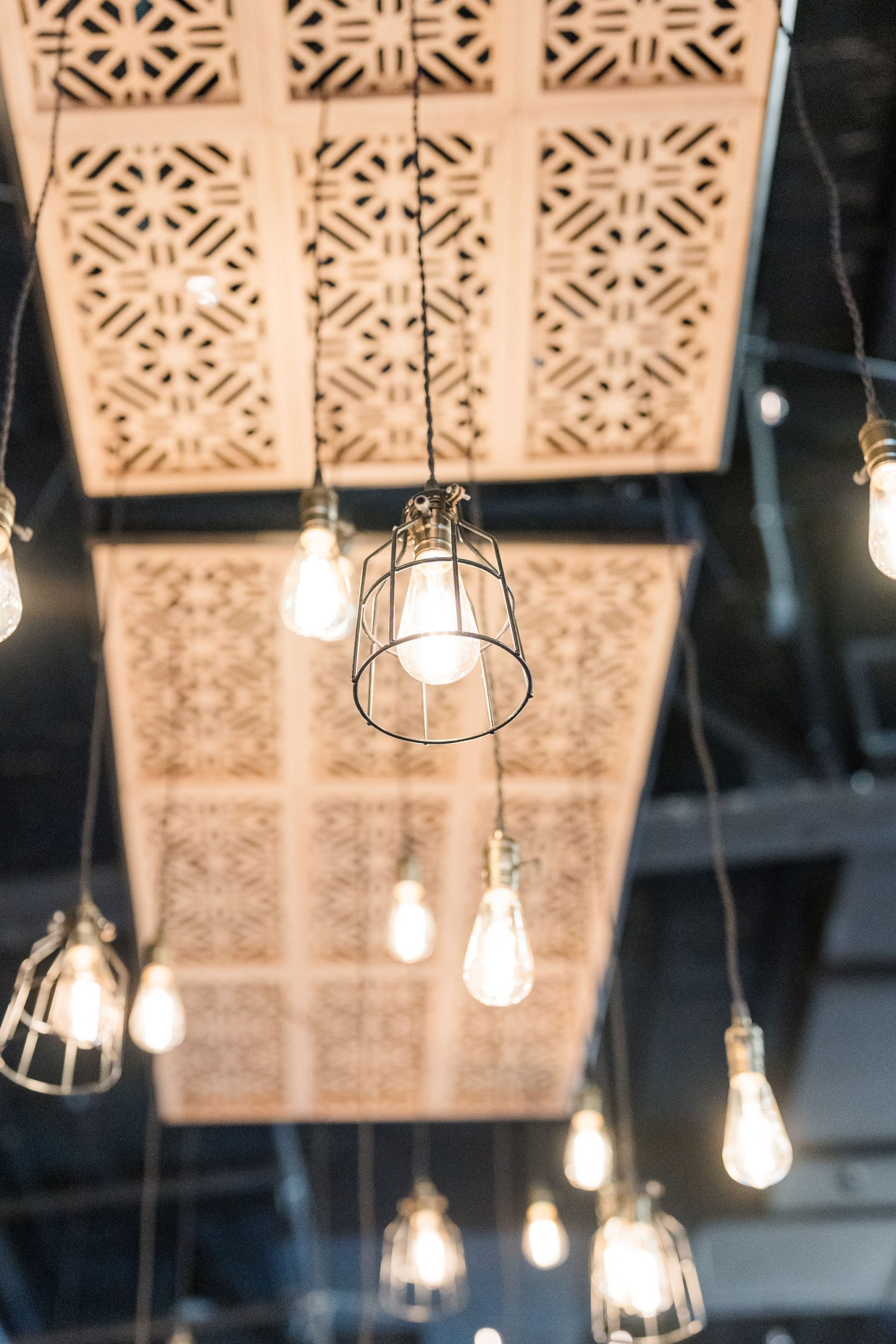 Cage pendant lights and wood-paneled ceiling at 10 South wedding venue in Janesville, WI