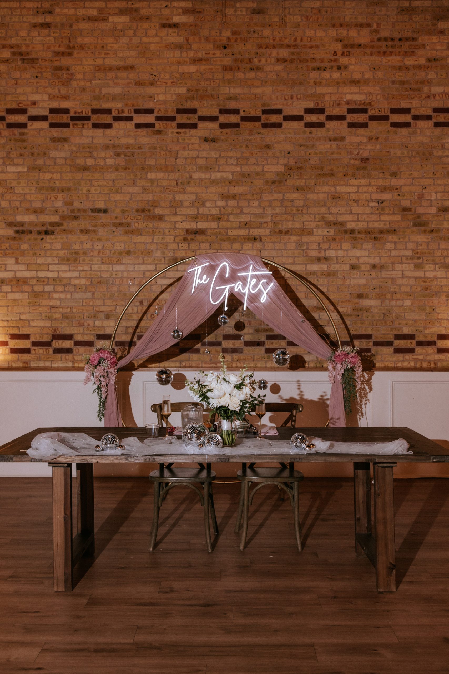 Sweetheart table with personalized neon sign and romantic draping at 10 South wedding venue
