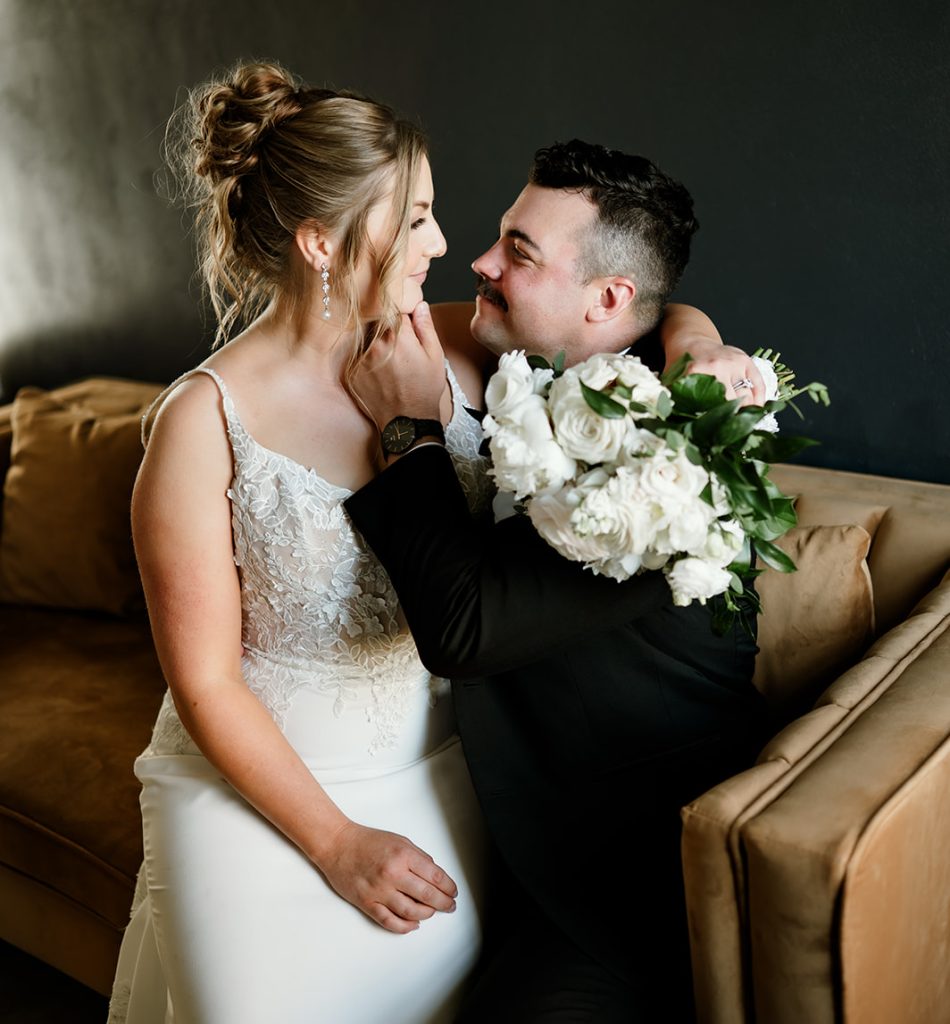 Bride and groom share a joyful moment indoors at 10 South wedding venue in Janesville, WI.